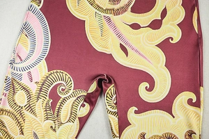 Close-up of dark red bodysuit fabric showing yellow and pink floral pattern texture