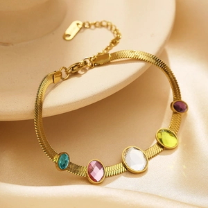 Close-up of gold snake chain bracelet featuring five vibrant oval-cut colorful zircons