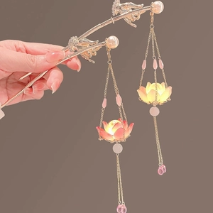 Detail of glowing lotus tassel hairpins with pink petals and gold metal finish