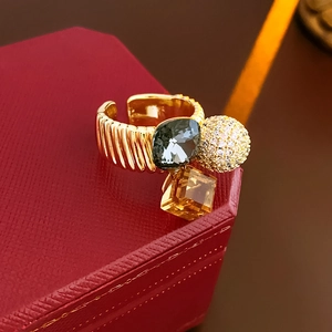Macro detail of gold plated ring with zircon stones on a red jewelry box edge