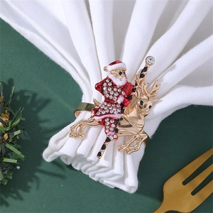 Close-up of a festive gold reindeer and Santa napkin ring with colorful rhinestones
