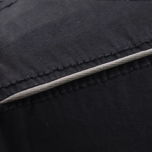 Close-up of premium black cotton fabric with beige piping detail and durable stitching