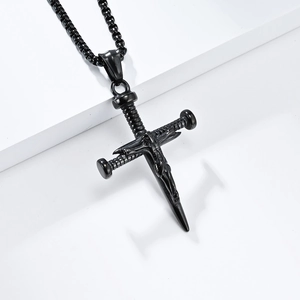 Retro black stainless steel crucifix necklace with Jesus carving on white pedestal