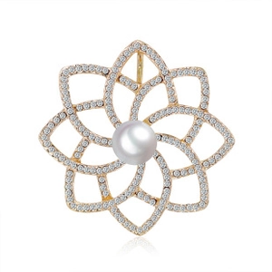 Detailed macro view of golden flower brooch with sparkling rhinestones and a central pearl