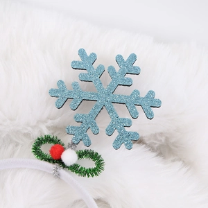 Close-up of blue glitter snowflake headband with red pom-poms and festive tinsel bow