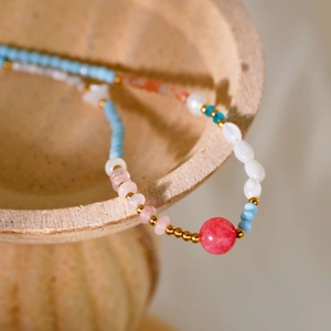 Handmade beaded necklace with natural pearls and blue stones on beige ceramic