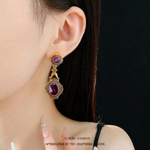 Vintage gold oval earrings with purple stones shown on a model for a luxury palace style look