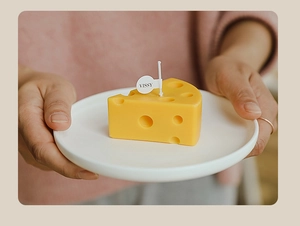Close-up of a cute mini cheese scented candle on white plate, perfect photo prop decor.
