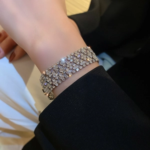 Close-up of a wide four-row silver rhinestone bracelet worn on a female wrist