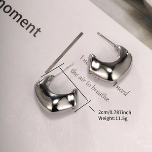 Detail of silver C-shape chunky hoop earrings with 2cm diameter and weight of 11.5g