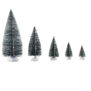 Mini green Christmas trees with snow-tipped needles on white bases for desk decor