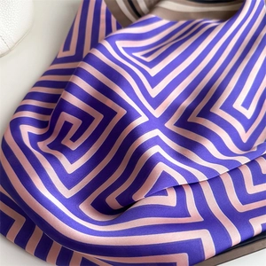 Détail de l'écharpe en soie avec motif de labyrinthe rose et violet et éclat satiné doux