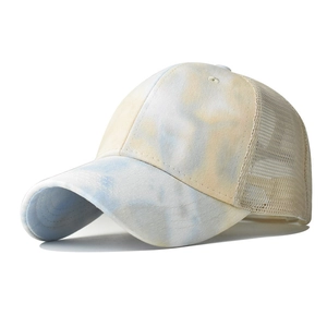 Detail view of tie-dye gradient cotton fabric and breathable mesh on baseball cap