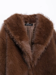 Detail of the high-quality long-hair faux fur collar and brand label in deep brown