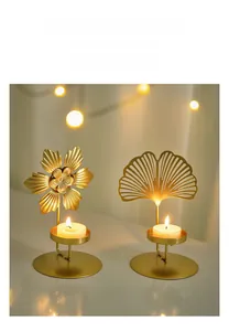 Detailed view of gold matte metal candle holders in flower and ginkgo leaf shapes