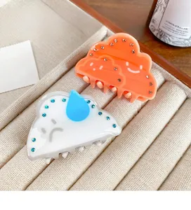 Detail of cute cloud acrylic hair claws with rhinestones on a corduroy jewelry tray