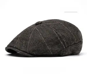 Close-up of coffee brown herringbone newsboy cap with red plaid details and wool texture