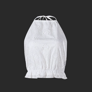 Close-up of white halter top featuring detailed eyelet embroidery and ruffled hemline