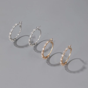Macro detail of gold and silver hoop earrings featuring sparkling round cubic zirconia