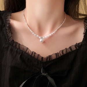 Elegante Silberkette mit abgestuften weißen Perlen an Model in schwarzer Spitzenbluse