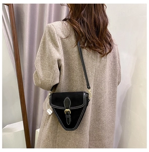 Detalle del bolso de silla de montar en PU negro mate con costuras blancas y hebilla