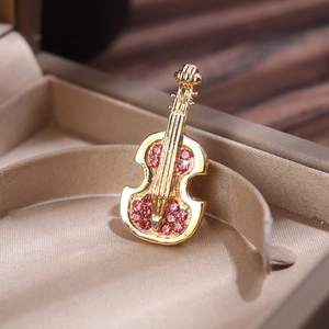 Exquisite gold violin brooch with red rhinestones displayed in a jewelry gift box