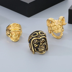 Detailed shot of three punk skull rings in gold and black steel with pilot and horn motifs