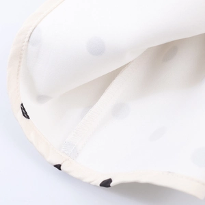 Chic white sleeveless top with black polka dots featuring premium hem stitching detail