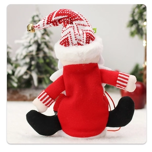 Rear view of a Christmas plush doll featuring red outfit and textured knit hat with bell