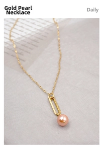 Close-up of gold paperclip chain necklace with a pink pearl pendant detail
