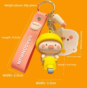 Close-up of cartoon pig on motorcycle keychain with dimensions and weight measurements