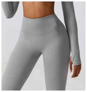 Detail of high-waisted gray yoga pants and long sleeve top with thumbhole cuffs