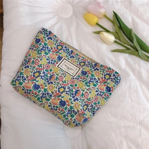Detailed macro view of the floral cotton makeup bag with zipper and decorative text label