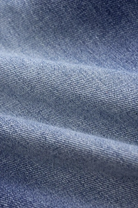 Détail macro du tissu denim bleu moyen de haute qualité avec motif de tissage sergé