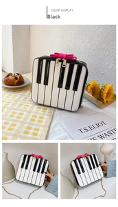 Detail of piano key handbag with pink bow decoration and gold chain strap