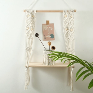 Detail of bohemian hand-woven cotton rope shelf with natural wood beads and shelf