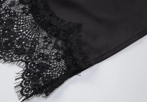 Nahaufnahme der zarten schwarzen Spitzenborte und des Satin-Stoffs am Kleid