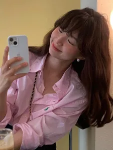Detail of pink cotton long-sleeve shirt with green equestrian embroidery on chest