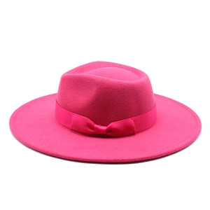 Detail of rose red wide brim wool fedora hat with matching satin ribbon and bow