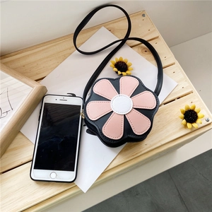 Detailed top view of flower-shaped PU leather bag next to smartphone for scale