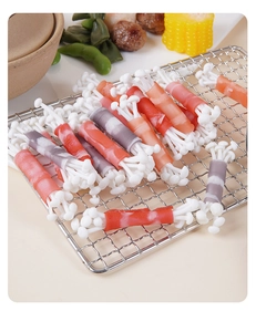 Close-up of realistic artificial beef enoki mushroom rolls on a BBQ grill rack