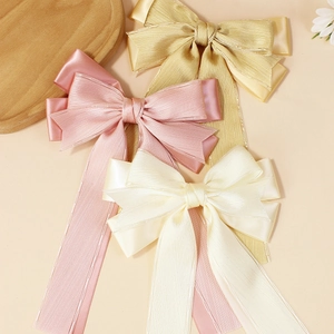 Handmade double layer satin bow hair clips in gold, pink, and beige with long ribbons