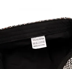Detail of white laundry care label on black lining showing 100% polyester material