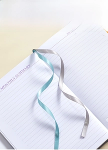 Detail view of the undated planner showing dual ribbon bookmarks in blue and silver grey