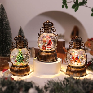 Close-up of three vintage bronze Christmas lanterns featuring Santa and Xmas tree scenes
