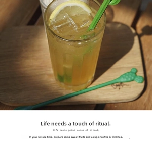 Detail shot of green cactus shaped stirrers in a refreshing summer iced drink