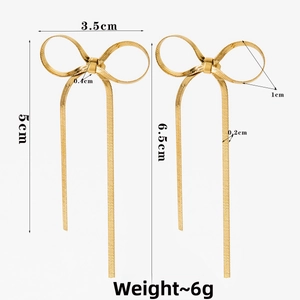 Detail view of gold bow earrings with snake chain tassels and precise size dimensions
