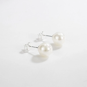 Detailed close-up of 925 sterling silver pearl studs with glossy white finish