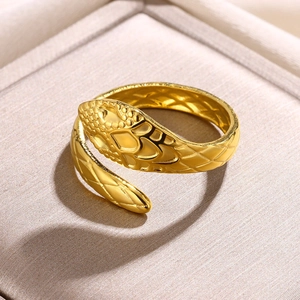 Macro detail of gold snake ring featuring textured scales and adjustable wrap design