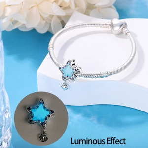 Luminous star charm on silver snake chain bracelet showing blue glow in the dark effect